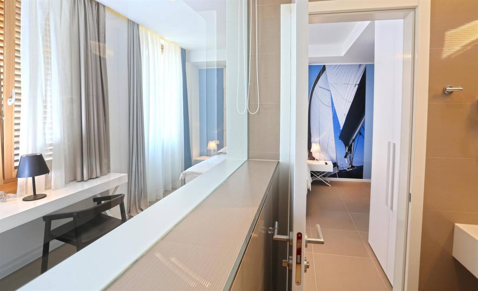 Room with curtains, a work desk and a view into the entry hall