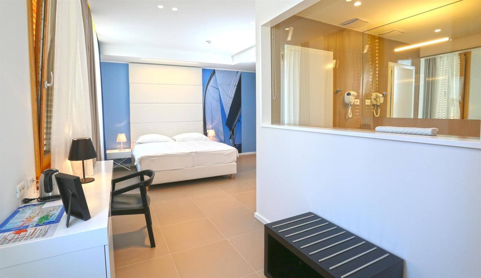 Room layout with the bed, desk and a glass partition to the bathroom